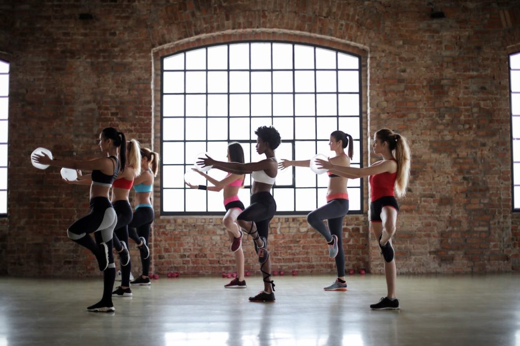 The Art of Drawing Readers In: Your attractive post title goes here Women practicing yoga poses in a brick-walled studio, promoting fitness and flexibility.